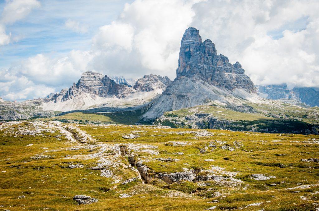 image of a landscape with green vegetation and mountains and a blue cloudy skyshowing deep depth of field camera settings