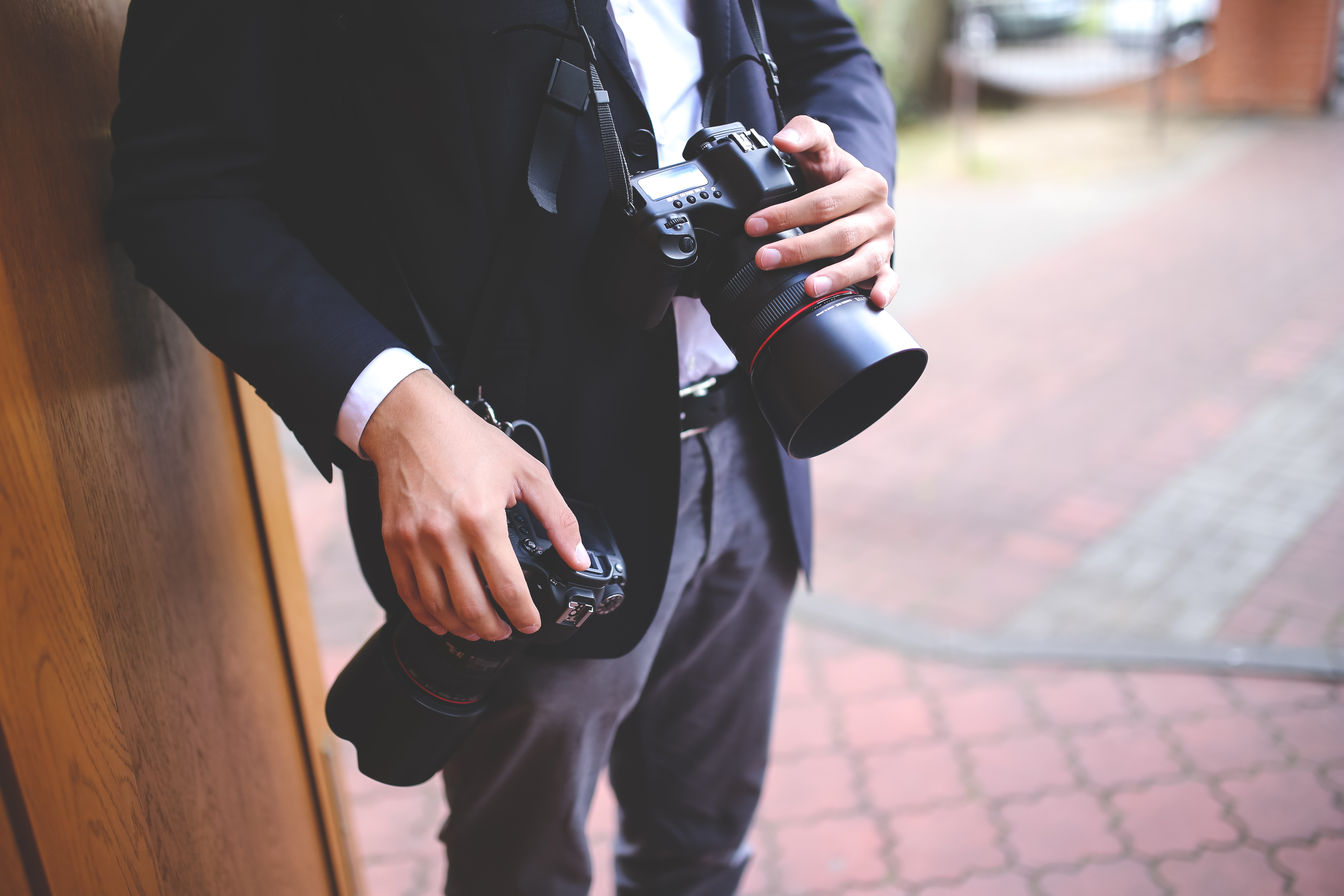 A photographer using two DSLR cameras on straps.