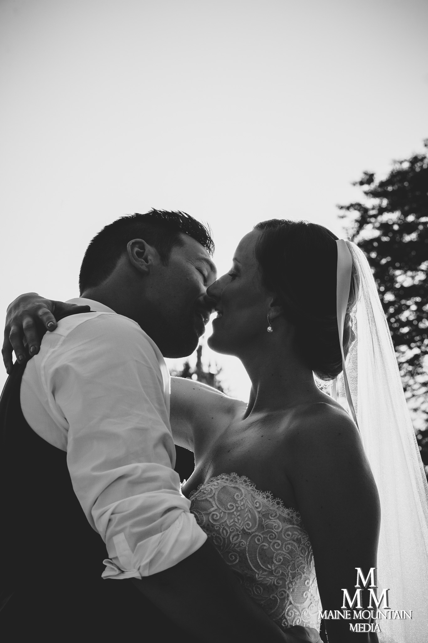 A bride and groom embracing and about to kiss.