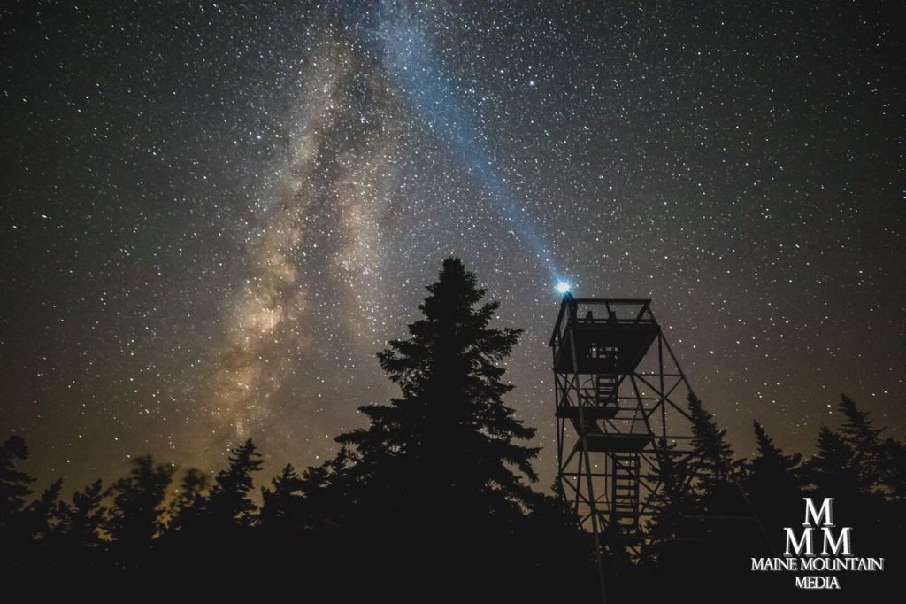 Nightscape image of a park ranger tower with a starry sky