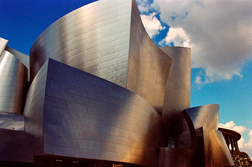 Cityscape photo of the Disney Hall at sunset with unique colors seen in the metal