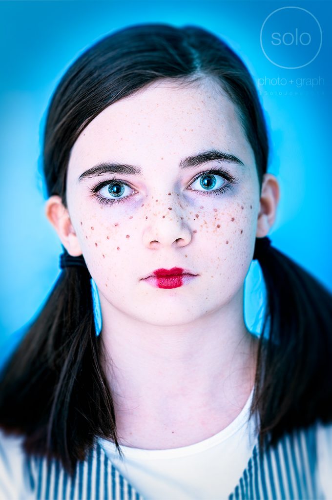 Photo of a young girl dressed up for Halloween with pig tails and freckles
