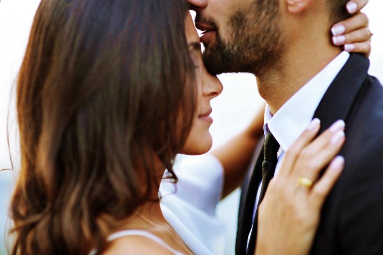 A man and woman embracing each other, with the man's chin resting on the woman's nose.