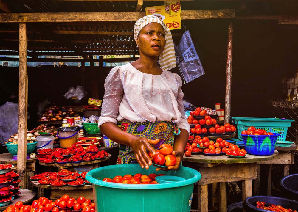 A woman selling vegetables at a market.