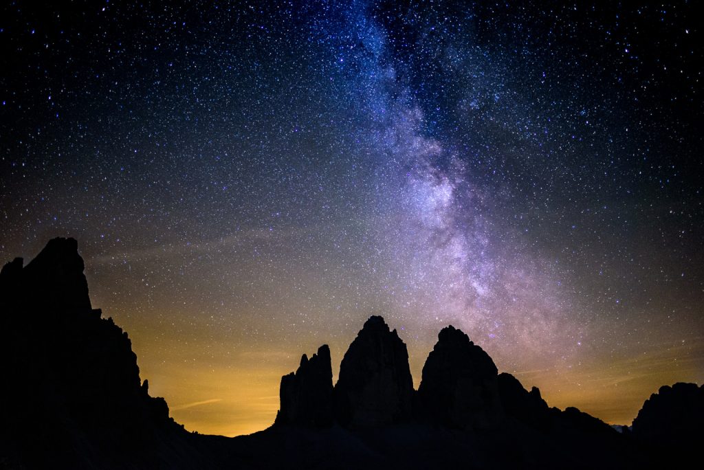 Astrophotography photo of the night ski behind desert mountains