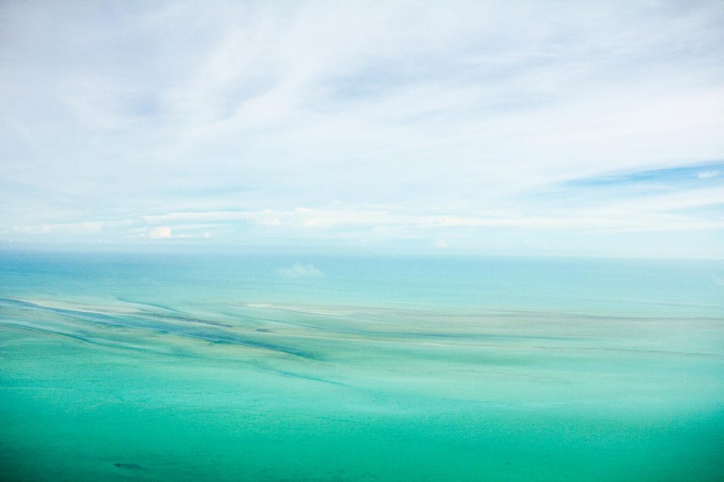 Fine art image of an ocean view with waves in water and blue sky with white clouds