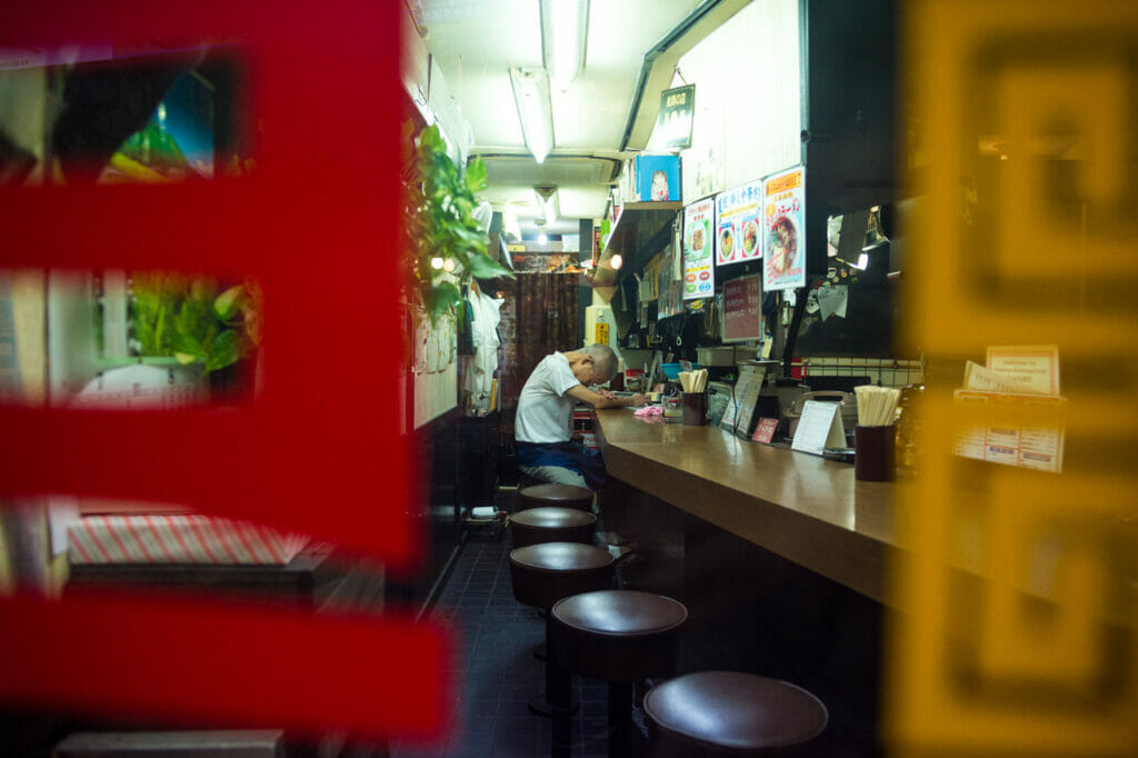 A man sitting at a restaurant with his head down.