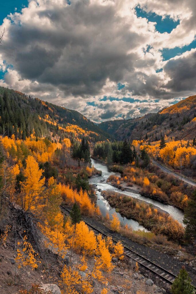 A creek and mountain range with a dramatic sky.